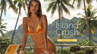 Model wearing bright bikini surrounded by palm trees. Island Crush Collection. 
