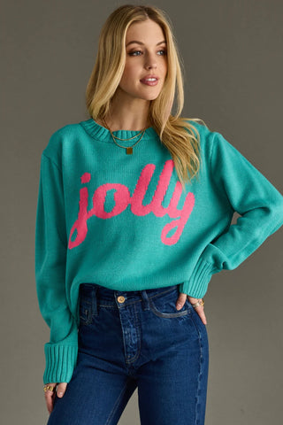 Woman wearing a teal sweater with pink 'jolly' text against a gray background