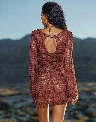 Woman wearing a brown mesh dress with a mountainous background
