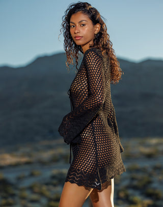 Woman wearing a black lace outfit with mountains in the background
