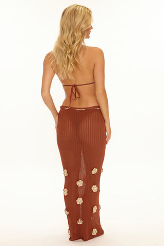 Woman wearing a brown floral outfit on a white background