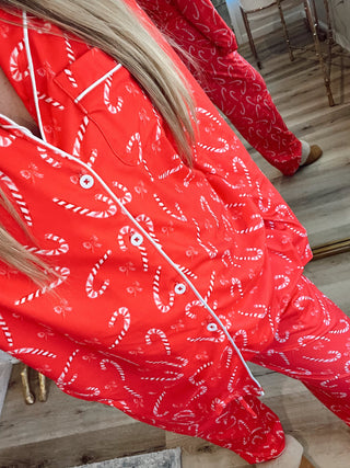 Person wearing a red outfit with candy cane patterns indoors.