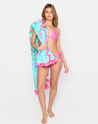 Vintage Rose Towel featuring a bright blue background with an allover pink rose floral print, finished with glossy pink satin ruffle trim and embroidered “Beach Bunny” logo. This romantic, feminine beach towel is perfect for adding a touch of vintage glam to your poolside or beach day.