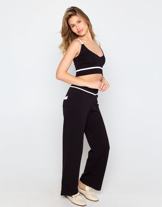 Woman wearing a black sports bra and pants on a white background