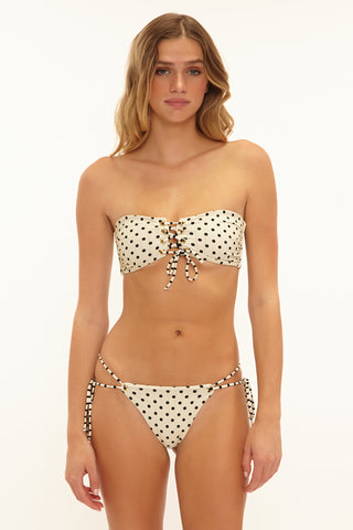 Woman wearing a polka dot bikini set on a white background