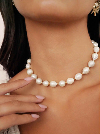 Pearl necklace worn by a person with a blurred background